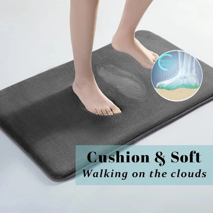 Grey memory foam bath mat shown absorbing water underfoot