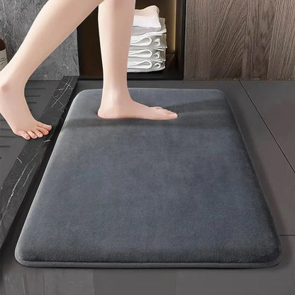 Grey memory foam bath mat underfoot beside a bathtub